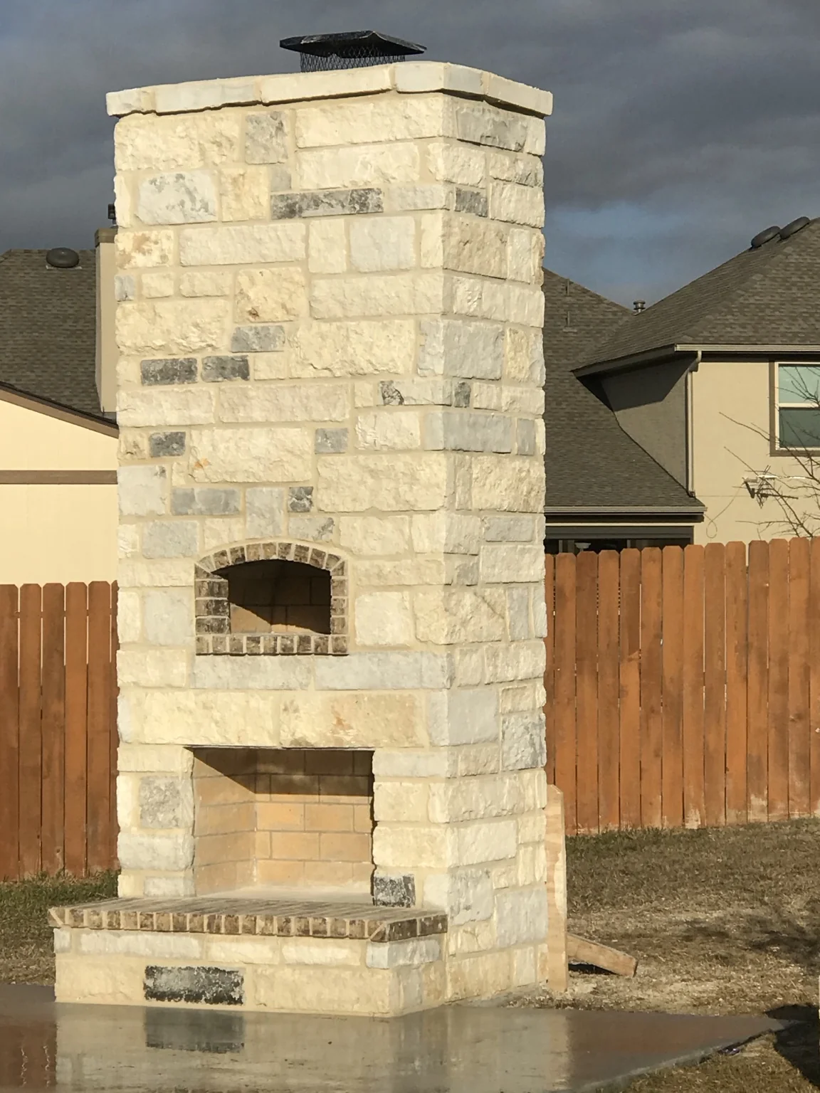 Outdoor stone fireplace by JJT Remodeling